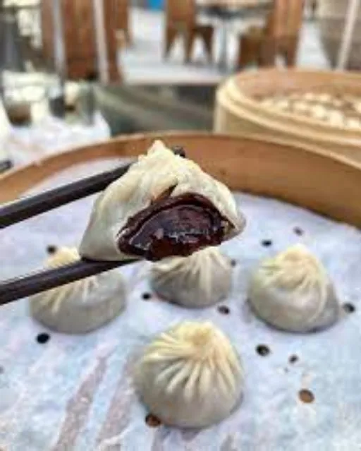 Chocolate Xiao Long Bao head in the chopstik ready to Eat