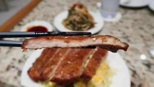 Slice of Prok Chop in the chopsticks ready to eat