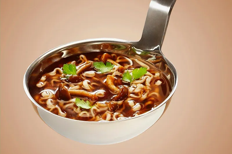 hot & sour pork soup in a large spoon