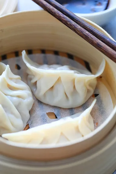 Closeup of Kurobuta Pork Dumplings placed in tray with beutiiful designs