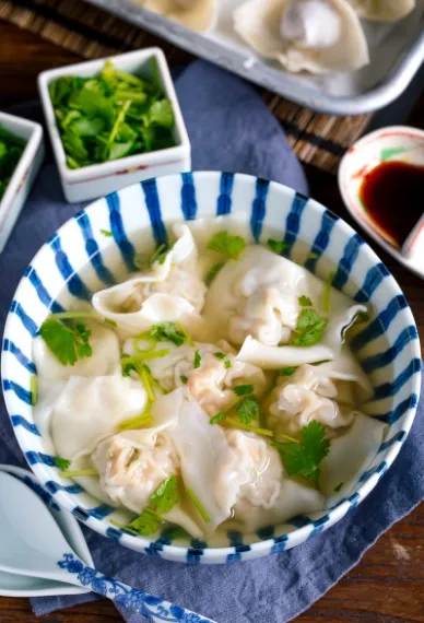 Shrimp & Kurobuta Pork Wonton Soup placed in a bowl and garnished with the vegetables