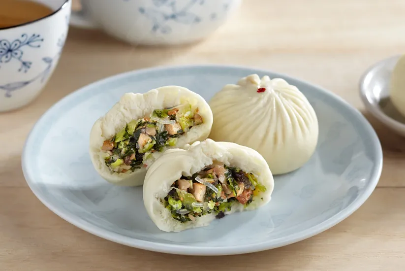 Vegan Buns placed in place and veggies are peeking through the dumpling buns