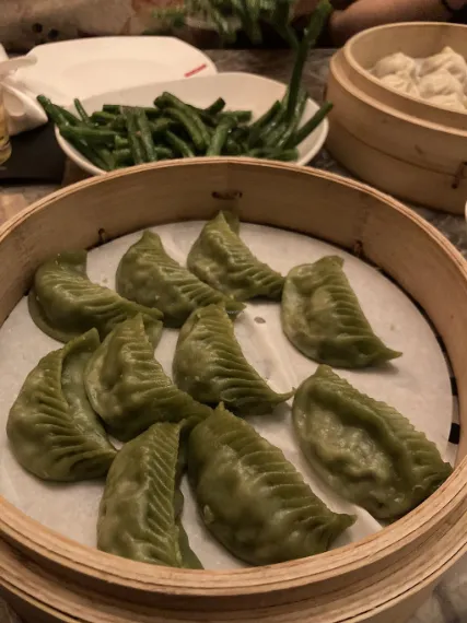 Vegan Dumplings placed in a tray for serving and at back chillies are placed
