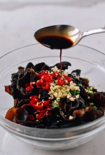 getting the dish ready for serving by pournig sauce on it by spoon