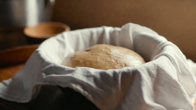 Bao dough rising in a bowl for Kurobuta pork buns becoming soft and airy